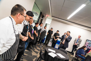 Chefs and Sous Chefs lined up along the wall in room 236 with Director Soto thanking them for making the meal. Chef Twila is third from the left wearing a black shirt and Chef Nephi is first to the left in a black and white striped apron
